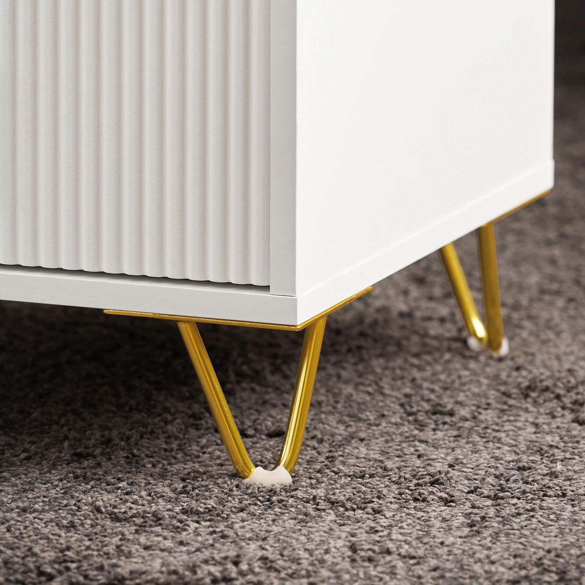 zoom sur les pieds dorés de la table de chevet blanche