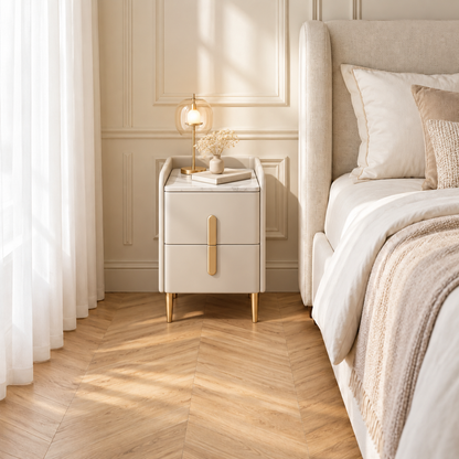 Même chambre aménagée avec une table de chevet beige, une lampe dorée et un livre à côté du lit.