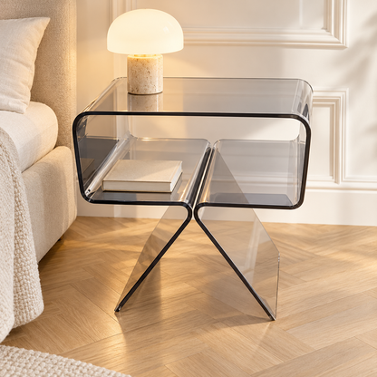 Table de chevet transparente avec une lampe et un livre dans une chambre avec moulures et parquet clair
