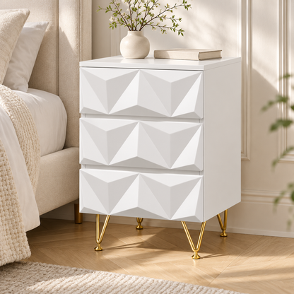 Chevet blanc à trois tiroirs en relief, décoré d’un vase et d’un livre dans une chambre lumineuse