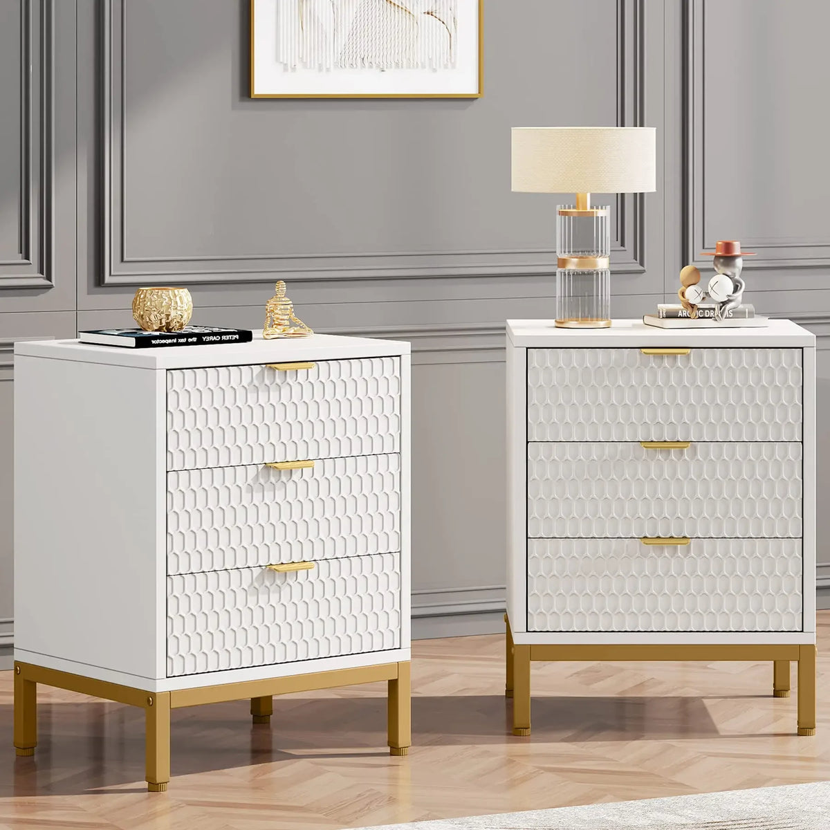2 Tables de chevet blanches et dorées avec une lampe et un vase dans une chambre lumineuse aux moulures crème.
