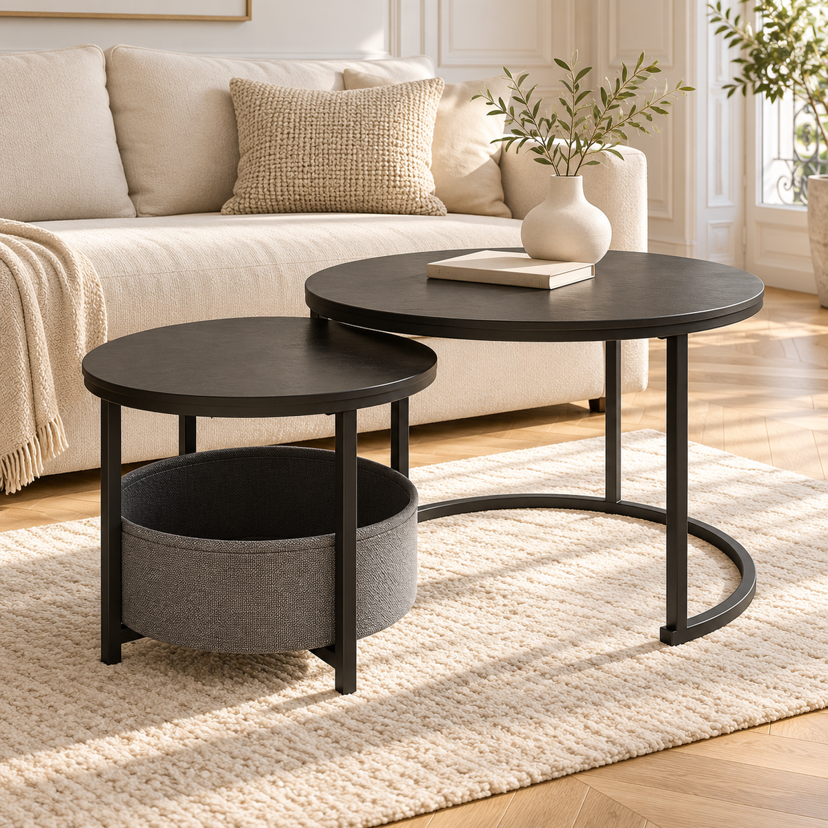 Deux tables gigognes noires avec panier gris dans un salon lumineux avec canapé crème et parquet clair
