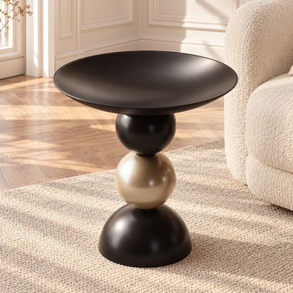Table d’appoint à plateau creusé noir et pied noir et doré dans un salon lumineux
