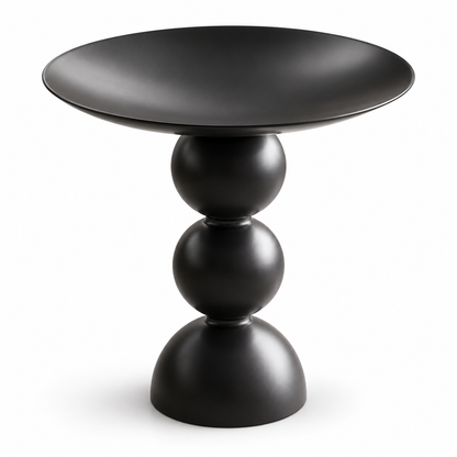 Table d’appoint noire avec pied sculptural arrondi et plateau en cuvette sur fond blanc