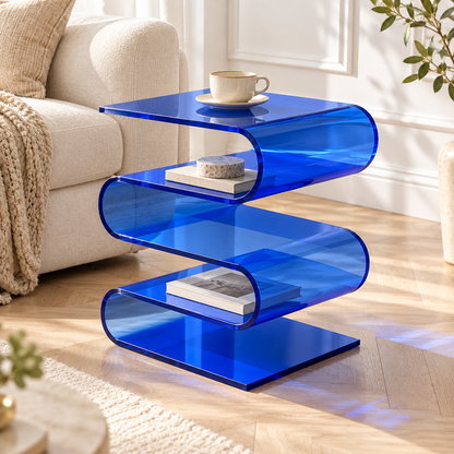 Table d’appoint bleue en forme de vague près d’un canapé écru, avec tasse et livres